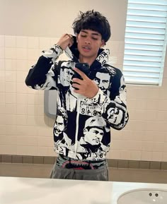 a man standing in front of a bathroom mirror holding a cell phone to his ear