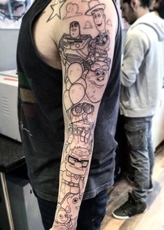 a man with a tattoo on his arm that has cartoon characters all over the entire arm