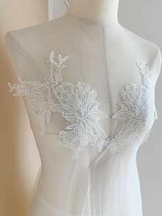 the back of a white dress with flowers on it