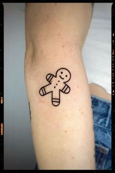 a person with a tattoo on their arm that has a small ginger figure on it