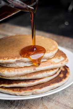 pancakes with syrup being poured onto them