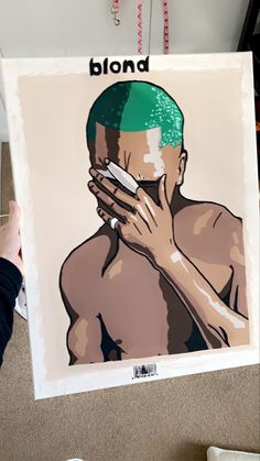 a person holding up a poster with an image of a shirtless man covering his face