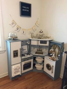 an old fashioned play kitchen with lots of appliances