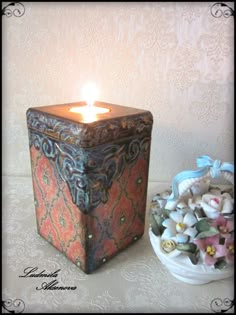 a candle is sitting next to a decorative box