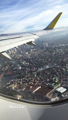 an airplane wing flying over a large city