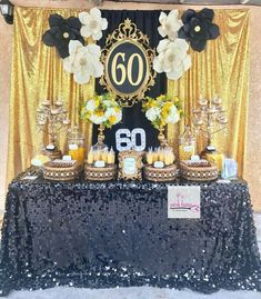 the table is set up with black and gold decorations