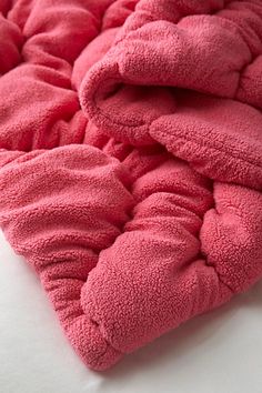 a close up of a pink blanket on a bed