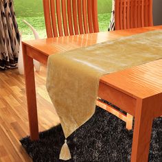 a wooden table with two chairs and a brown table cloth on it's edge