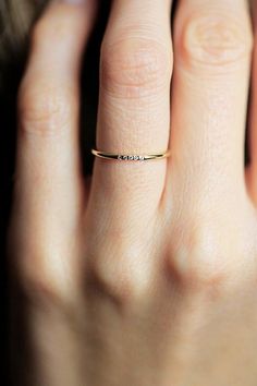 a woman's hand with a gold ring on her left hand and the word love written in it