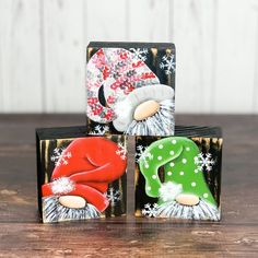 three christmas themed coasters sitting on top of a wooden table