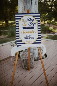 a sign that is on top of a wooden easel in front of a tree