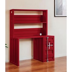 a red bookcase with drawers and a door on the bottom shelf is in front of a white wall