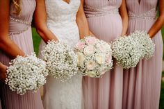 the bridesmaids are holding their bouquets with baby's breath in them