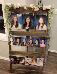 an old wooden rack with photos hanging on clothes pins and flowers around the photo holders