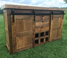 a large wooden cabinet sitting on top of a lush green field