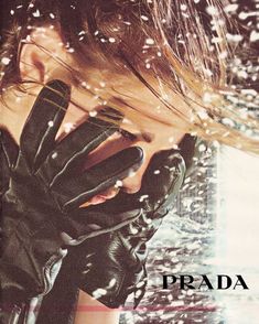 a woman in black gloves covering her face with her hands and the words prada above her head