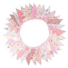 a pink and white wreath with lots of different colored paper pieces on it's sides