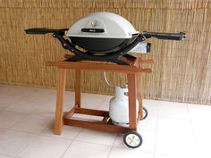 a bbq grill sitting on top of a wooden cart