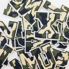 the letters are made out of camouflage print paper and have been cut into smaller pieces