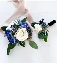 two white and blue flowers sitting on top of a table