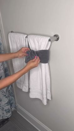 a woman is hanging towels on a towel rack