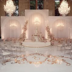 an elaborately decorated wedding ceremony room with chandeliers and flowers on the wall