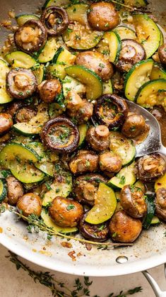 a pan filled with cooked zucchini and mushrooms