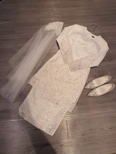 the wedding dress and shoes are laying on the floor