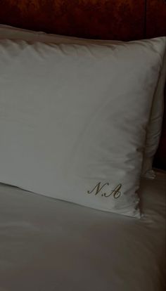 a white pillow sitting on top of a bed