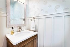 a bathroom with a sink, mirror and towel rack on the wall next to it