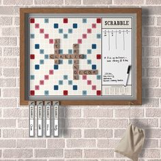 a scrabble board hanging on a brick wall