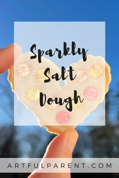 someone holding up a heart shaped doughnut with the words sparkly salt dough on it