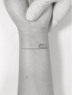 a small elephant tattoo on the wrist is shown in this black and white photo,