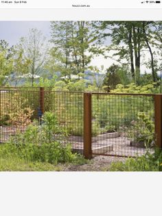 an image of a fenced in area with trees and bushes behind it on the screen