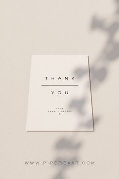 a thank you card sitting on top of a table next to a leafy plant