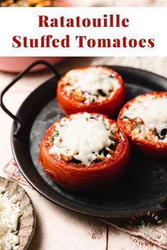 three stuffed tomatoes on a black plate with the words ratatoulie stuffed tomatoes