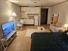 a living room filled with furniture and a flat screen tv on top of a hard wood floor