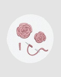 the sewing needle is next to two pink roses on a white circle with scissors and thread