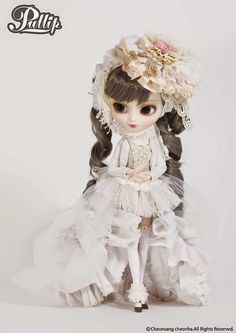 the doll is wearing a white dress with flowers in her hair