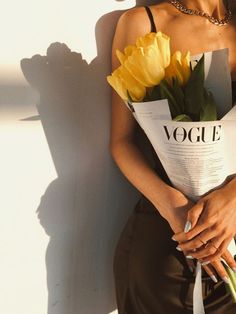 a woman holding a bouquet of yellow flowers