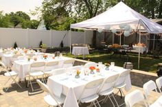 tables and chairs are set up for an outdoor party with white linens on them