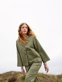 Light summer jacket in soft dusty green called laurel leaf. Made of heavy woven cotton and loose fit with two front pockets. Closing in front with large coconut buttons. 100% organic and GOTS certified production. Light Summer Jacket, Laurel Leaf, Dusty Green, Woven Cotton