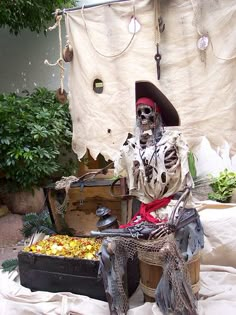 a skeleton sitting on top of a wooden trunk next to a box filled with fruit