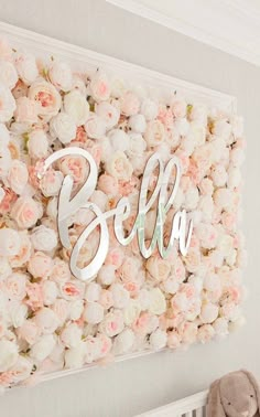 a baby's room decorated with flowers and a name sign above the crib