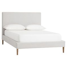 a bed with white sheets and pillows on it's headboard, against a white background