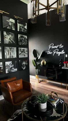 a living room with black walls and pictures on the wall