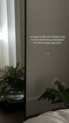 there is a mirror with a quote on it next to a plant in front of a window