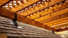 the roof of a house with wood shingles and a weather vane on it's side