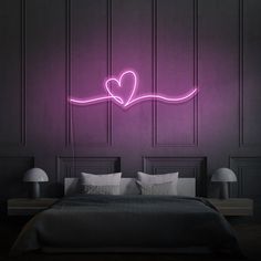 a bed in a room with a purple light on the wall and a heart shaped neon sign above it