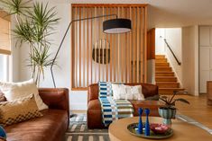 a living room with two couches and a coffee table in front of a staircase